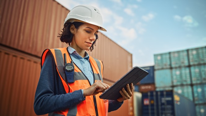 Woman holding a tablet at work, approving timesheets for her team to ensure accurate payroll processing